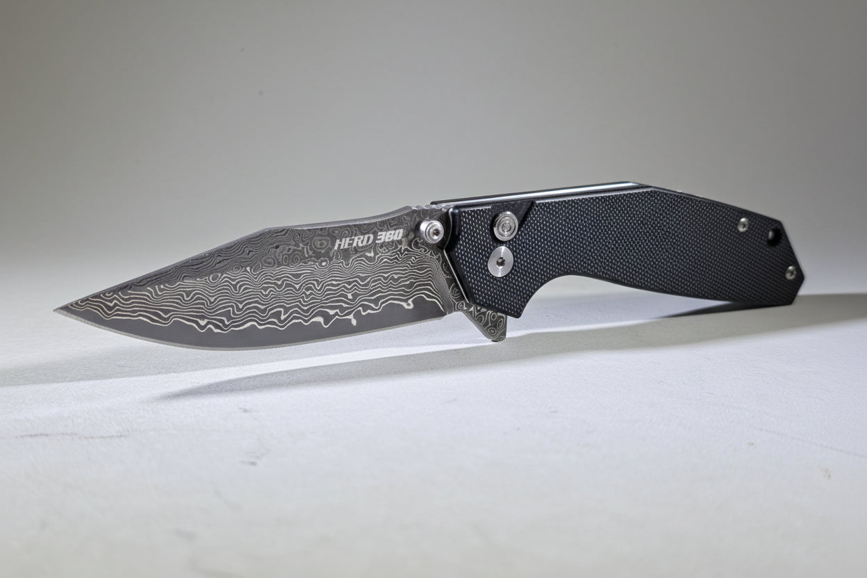 Folding knife with a textured blade on a white surface