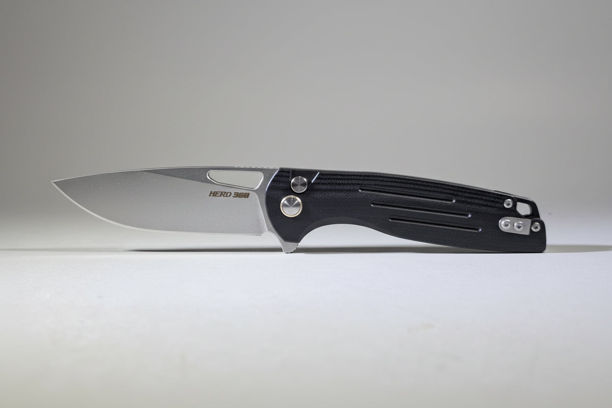 Folding knife on a white surface with a blurred background
