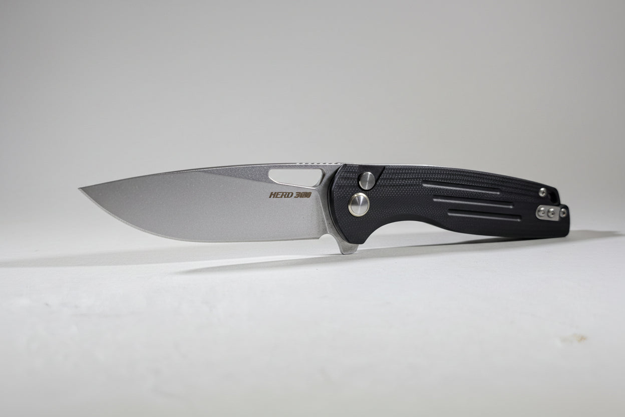 Folding knife on a white surface with a blurred workshop background