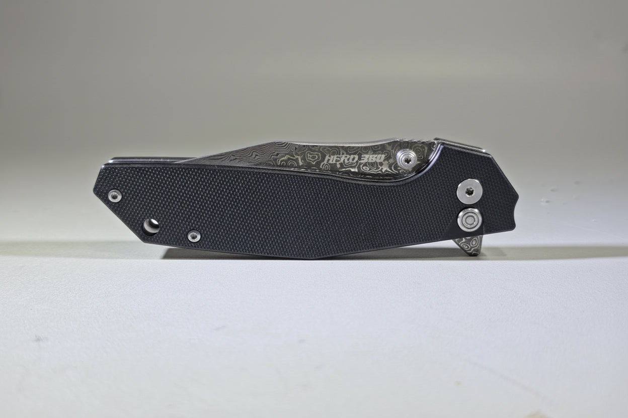 Black folding knife with visible branding on a white surface
